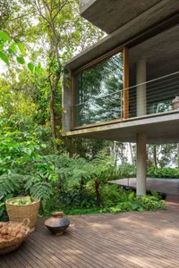 A modern landscape featuring a wooden deck overlooking lush greenery.