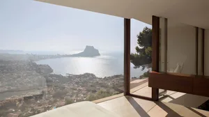 Modern interior with glass view overlooking coastal cityscape and mountains