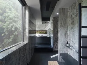 Modern bathroom featuring marble walls and floor, large window with natural light, and sleek black fixtures.