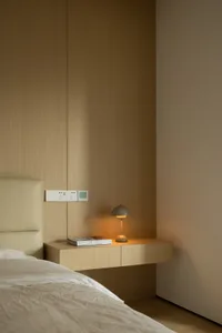 A minimalist bedroom with a wooden headboard and textured bedding.