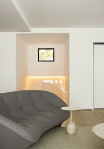 Modern, minimalist living room featuring a gray sofa