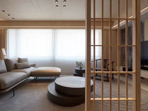 A modern minimalist living room with a wooden floor, white furniture, and a round marble coffee table.