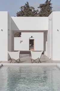 A minimalist white pool and spa area with a modern design, featuring clean lines and a simple color palette.