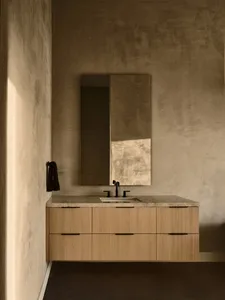Modern bathroom with a concrete vanity and faucet against a textured wall