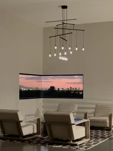 A modern living room with textured paint walls, minimalist furniture, and a large window overlooking a cityscape at sunset.