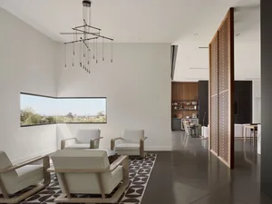 A modern living room with white furniture and concrete floors.