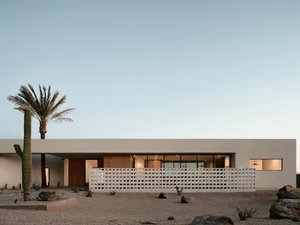 Modern residential house with concrete exterior and large windows.
