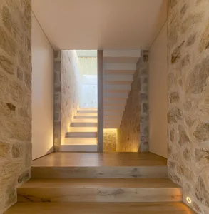 Modern staircase with wooden steps and walls.