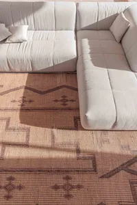 A modern white sofa with a tiled pattern floor rug in a contemporary living room setting.