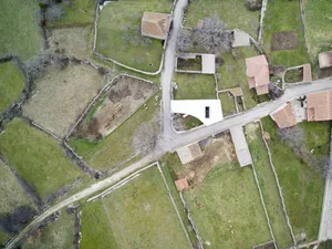 Aerial view of a village with agricultural fields and buildings.