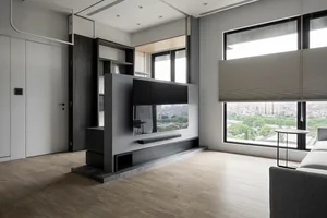 A modern living room featuring metallic elements and wooden flooring and furniture.
