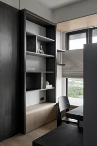 A modern minimalist workspace featuring dark wood furniture and shelves.
