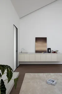 A minimalist living space featuring a wooden floor and a white cabinet with a sink and artwork.