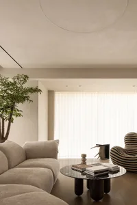 Sofa, chair, and coffee table in a minimalist living room with neutral-colored textiles.