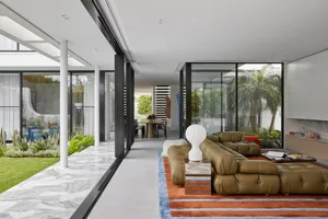 Well-lit, modern living room with a leather couch.