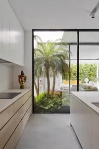 A modern kitchen featuring glass cabinets and concrete floors.
