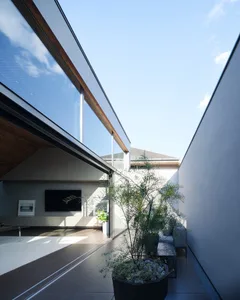 A modern living room featuring glass walls and concrete flooring.