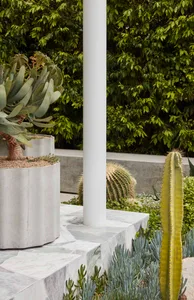 Concrete columns with marble accents and plants in planters
