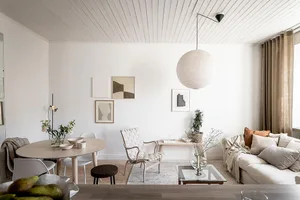 A contemporary living room with minimalist design, featuring timber furniture, a fabric sofa, and a glass coffee table.