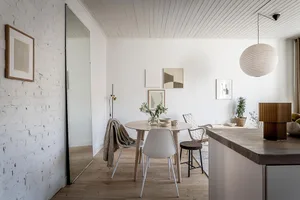 A minimalist interior with white brick, wood, and concrete materials.