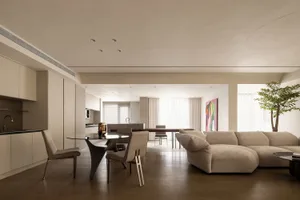 現代簡約客廳，舒適的米色L型沙發搭配柔軟抱枕，並設有俐落餐區