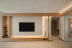A modern living room featuring a wooden wall with a mounted television and a metallic bear statue.