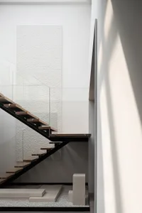 A modern staircase with black metal rails and wooden steps.