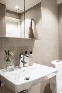 Modern bathroom with ceramic tiles, sink, faucet, and hand towels in a contemporary style