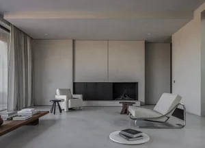 A modern minimalist living room with concrete and steel finishes.