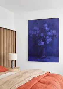 Bedroom featuring a modern design with a neutral color palette, upholstered headboard, and contemporary artwork.