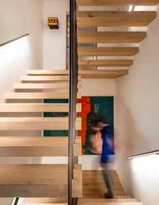 Modern interior with wooden staircase and abstract painting.