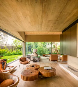 Modern living room with wooden tables, leather seats, and glass elements.