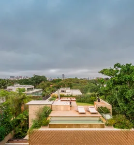 A modern rooftop deck featuring a pool and lounge area surrounded by greenery.