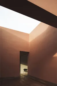 A minimalist space featuring concrete walls and glass ceiling.