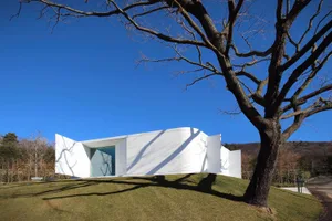 A minimalist, white, concrete house with large windows