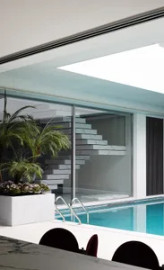Modern swimming pool interior with marble and glass elements.
