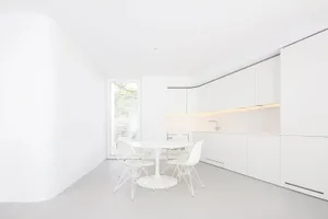 A minimalist white kitchen with modern design elements.