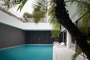 Modern residential exterior featuring metal, glass, and concrete materials.