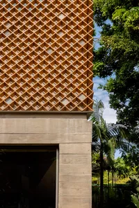 Modern building exterior featuring a wooden lattice design for ventilation and aesthetic appeal.