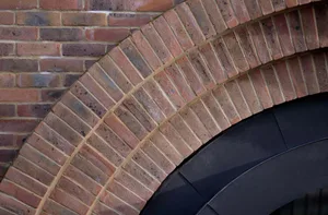 Detailed view of a brick outer building structure, showcasing architectural elements such as arches and materials.
