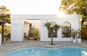Modern, minimalist house with a concrete exterior and poolside view.