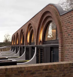 A modern architectural building with brick exterior featuring large arched windows.