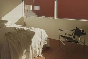 Minimalist bedroom featuring a comfortable bed with a textured blanket.
