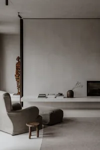 A minimalist living room featuring concrete surfaces and wooden elements.