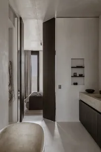 現代極簡浴室，混凝土地板與牆面，搭配獨立式浴缸與嵌入式洗手台。