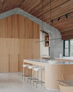 A modern kitchen with a marble countertop and wooden cabinets.