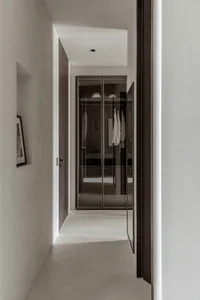 Modern minimalist closet interior with glass sliding doors.