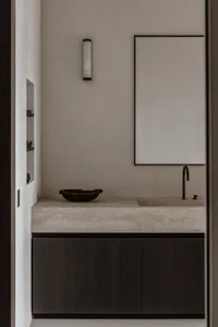 Modern bathroom featuring a concrete countertop with a sink, minimalist cabinet, and a rectangular mirror.