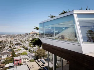 A modern cityscape view featuring glass terraces overlooking a densely populated urban area.