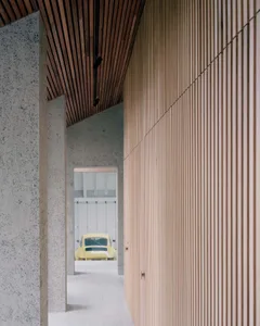 A modern interior design featuring concrete walls and wooden slat ceiling.